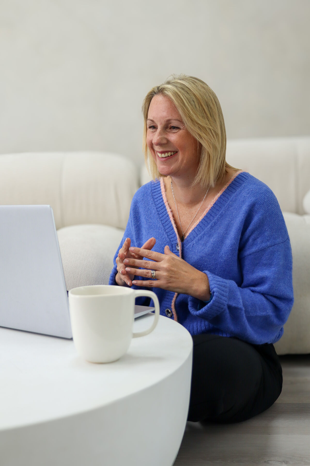 Woman working on a laptop with a coffee mug, corporate brand photography