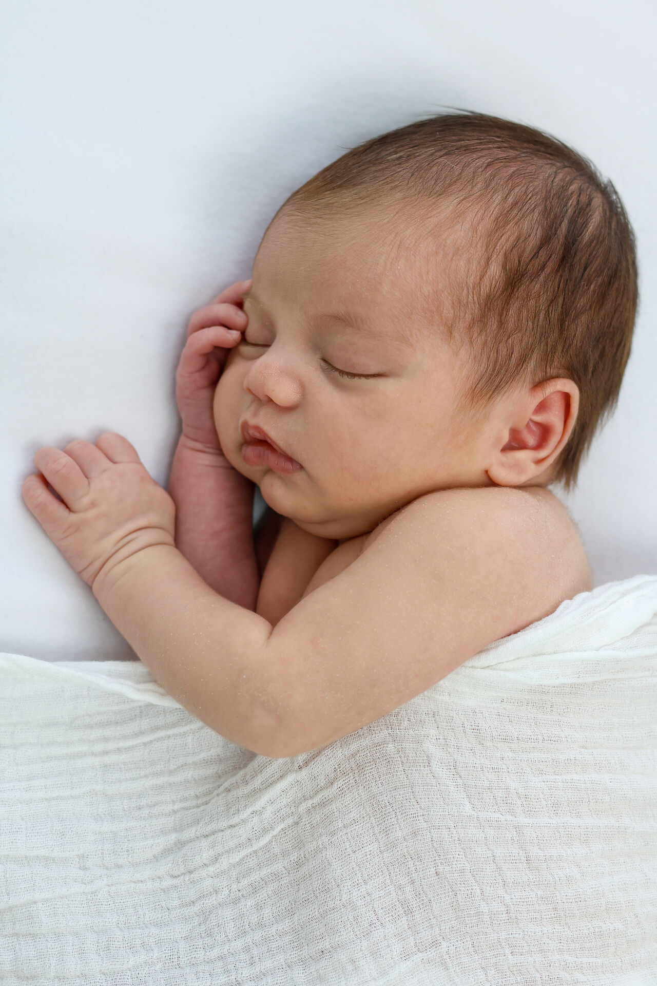 Sleeping newborn resting hand on cheek at Little Cloud Grey Studio